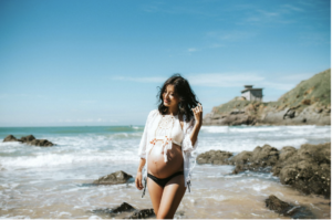 Pregnant Woman walking on the beach 